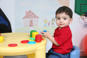 Toddler playing with colorful dough toy